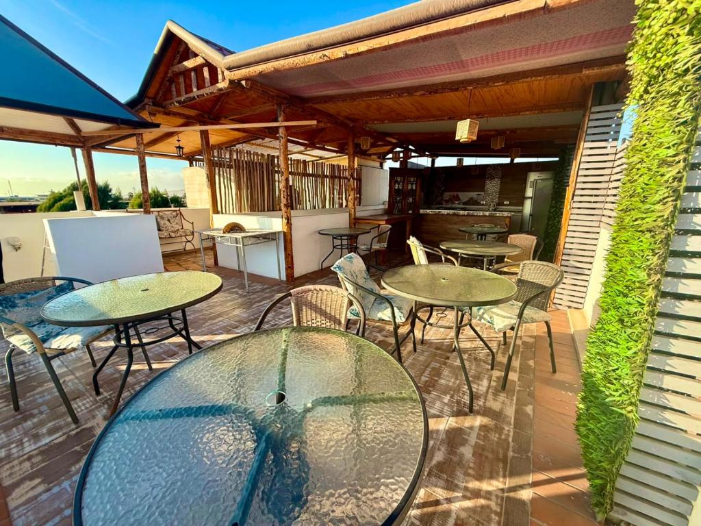 a patio with tables and chairs on a deck at Le Grey Arica in Arica