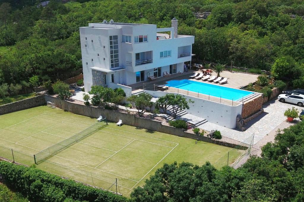 an aerial view of a house with a tennis court at Villa Vrbnik in Vrbnik