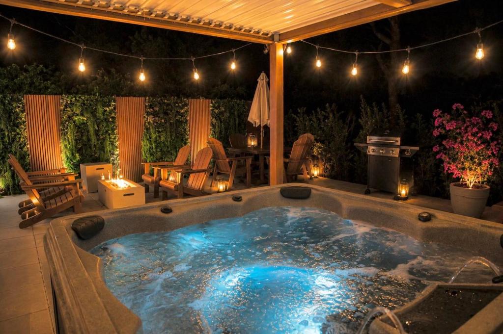 a hot tub in the middle of a patio at night at Boho Bliss - Reset & Recharge Wellness House in Naples