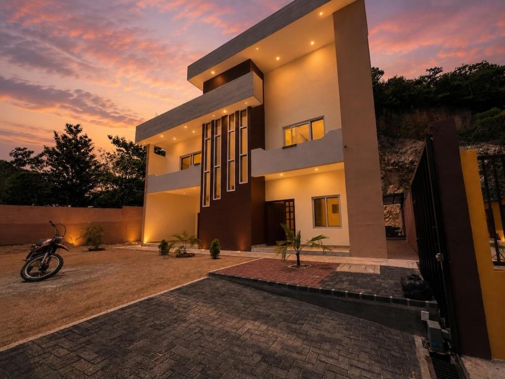 a house with a motorcycle parked in front of it at "Selva maya stay" kitchen and spacious private parking in Flores
