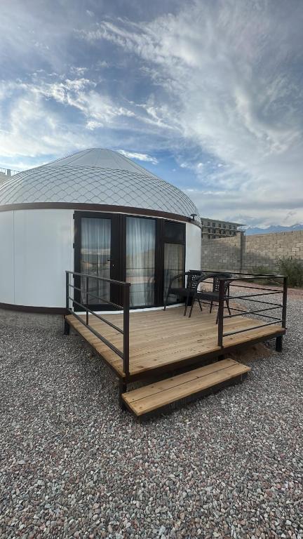 a large building with a deck with a table at Tangnuru eco yurts in Bosteri