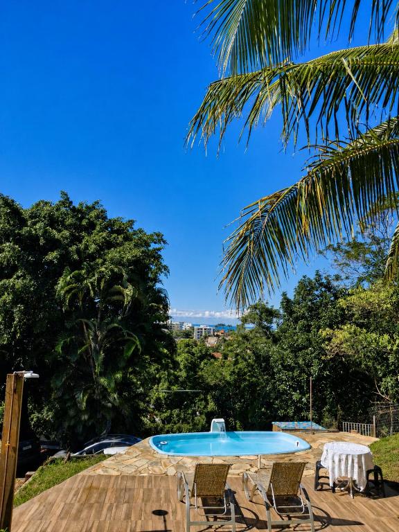 a table and chairs on a deck with a pool at Casa da Praia Costazul in Rio das Ostras