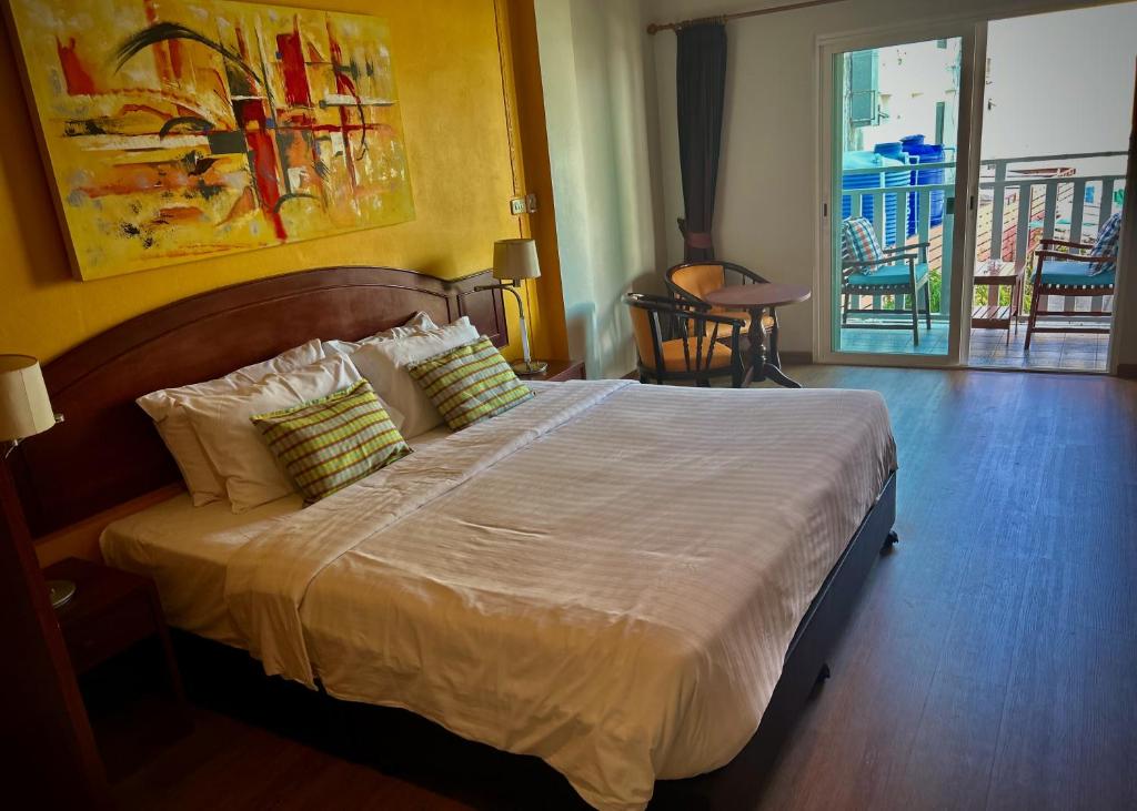 a bedroom with a large bed with white sheets and pillows at Sugar and Spice Inn in Kata Beach