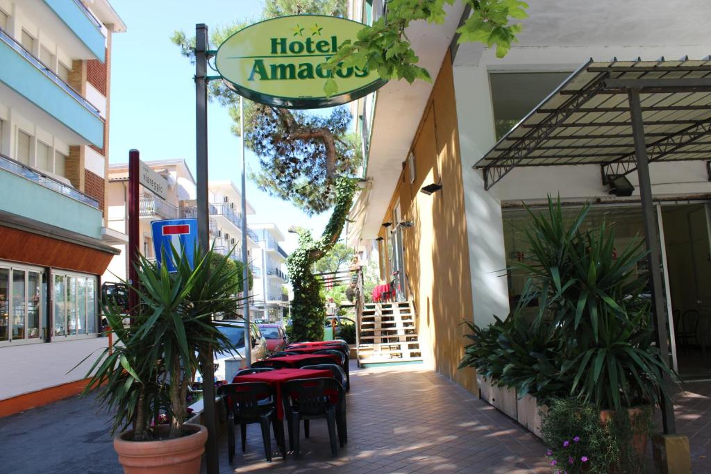 リミニにあるHotel Amadosの通りにテーブルと椅子が並ぶレストラン