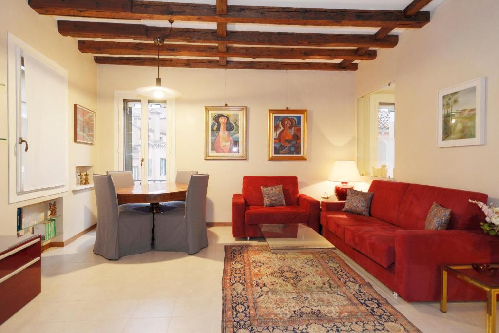 uma sala de estar com um sofá vermelho e uma mesa em Ca San Salvador em Veneza
