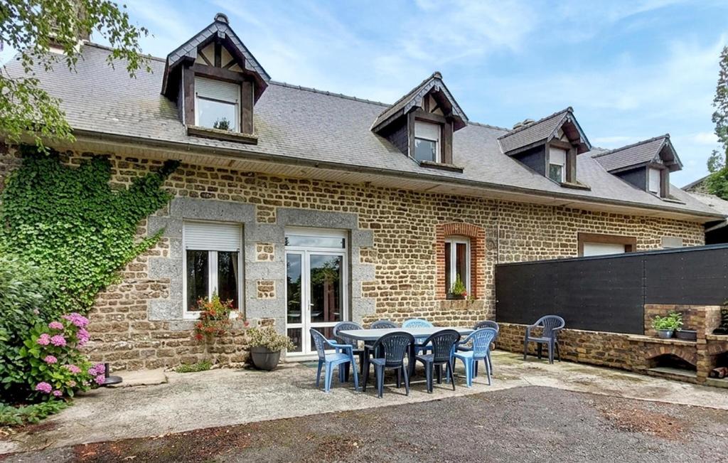 a brick house with a table and chairs at Maison Mitoyenne Avec Spa in La Chapelle-Urée