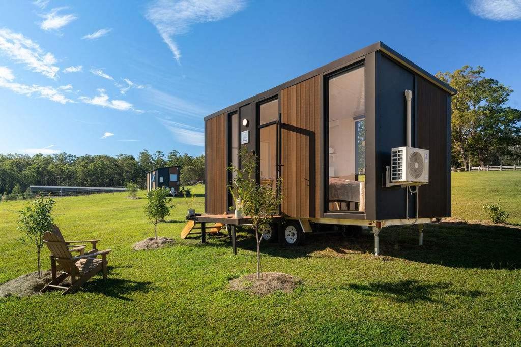 a tiny house sitting on top of a field at Tiny Tallowood by Tiny Away in Glenreagh