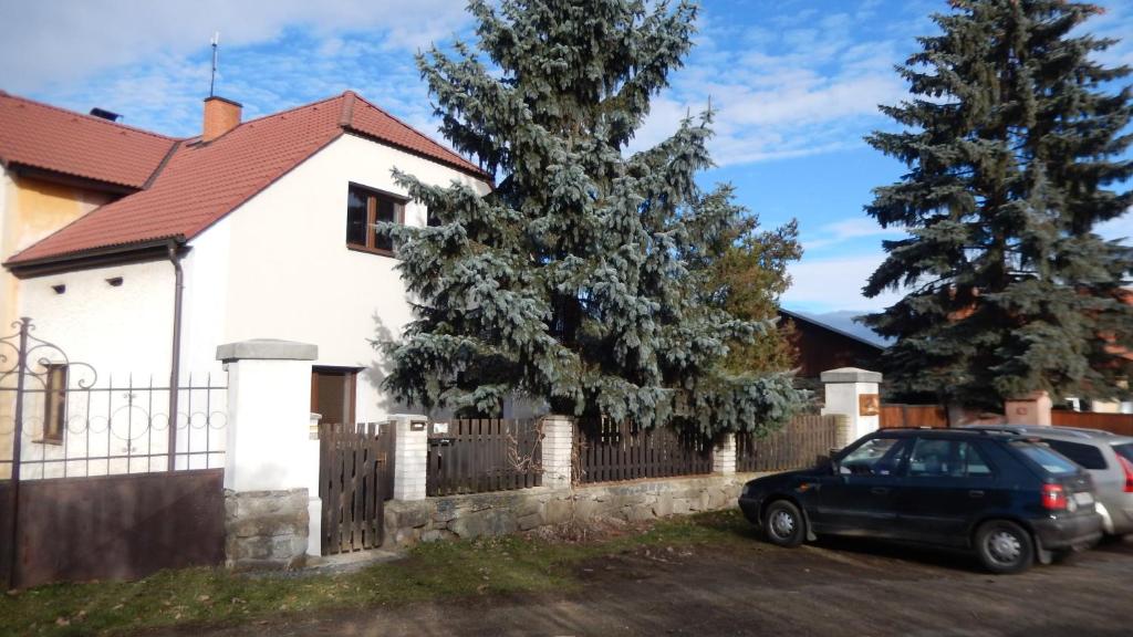 a car parked in front of a fence in front of a house at Apartment U Lochů in Kňovičky