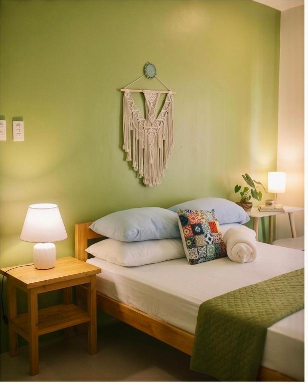 a bedroom with a bed and a table with a lamp at Hooga Home in Cebu City