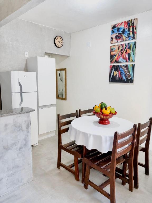 a kitchen with a table with a bowl of fruit on it at Casas do Matteo - 2ª Praia in Morro de São Paulo
