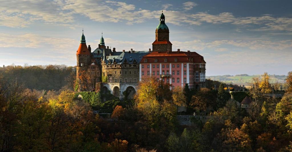 un castillo en la cima de una colina con árboles en Wanda, en Szczawno-Zdrój