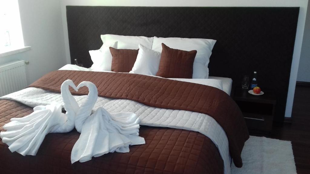 a bedroom with a bed with two swans made out of towels at Noclegi Prestige in Nowy Sącz