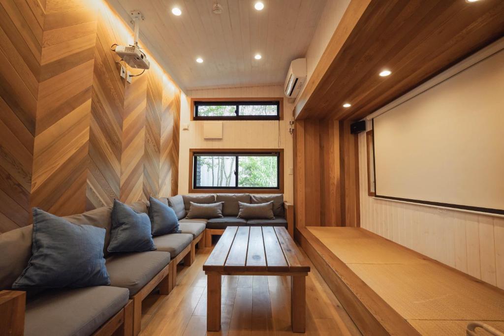 a living room with a couch and a screen at Tiny Base The River in Kawazu