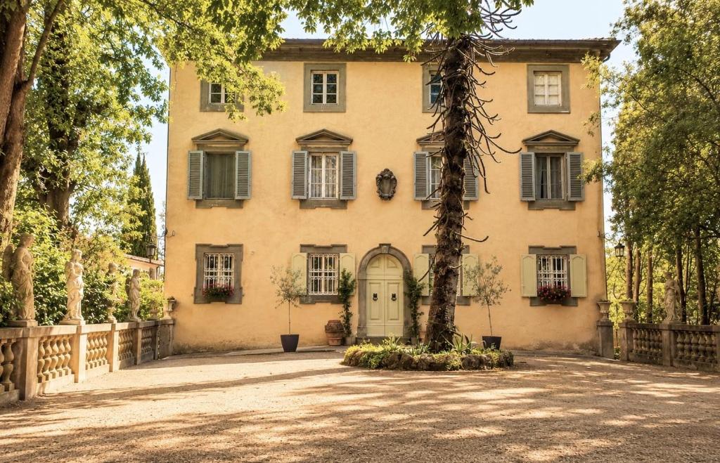a large house with a tree in front of it at Villa Amore Tuscany in Capannori