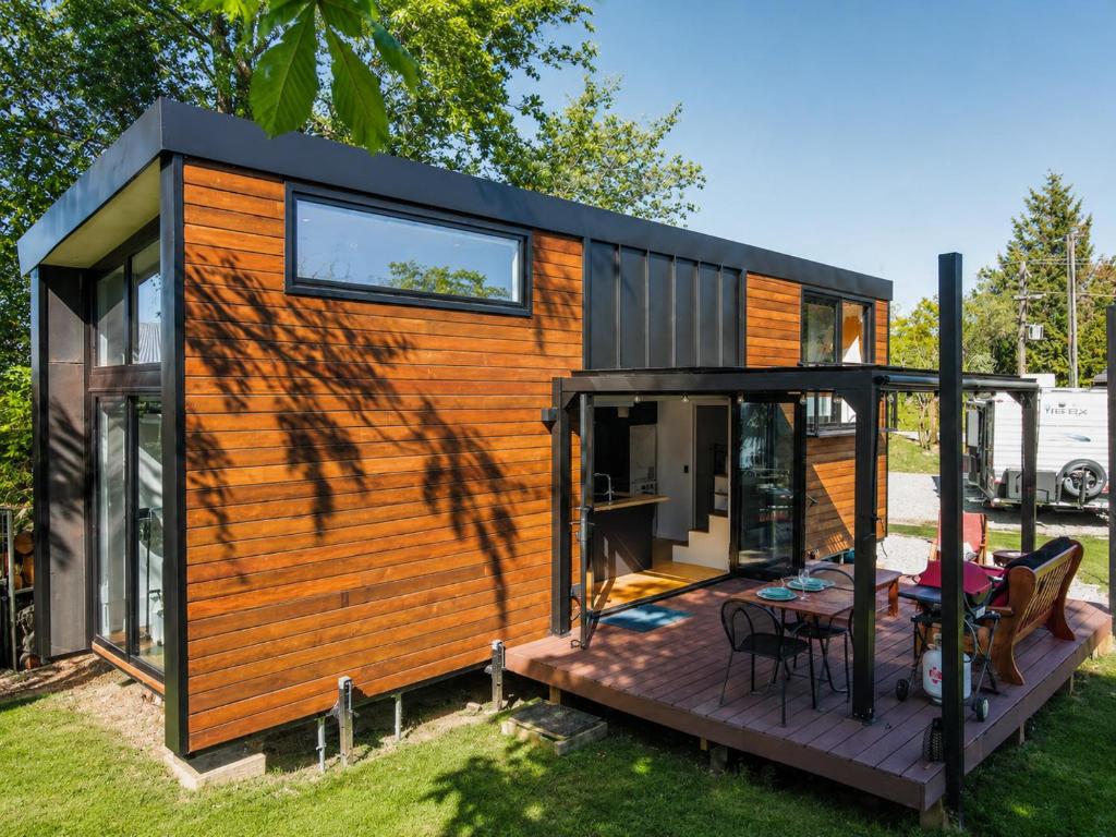 a tiny house with a deck and a table at Tiny House - Big Luxury in Wanaka