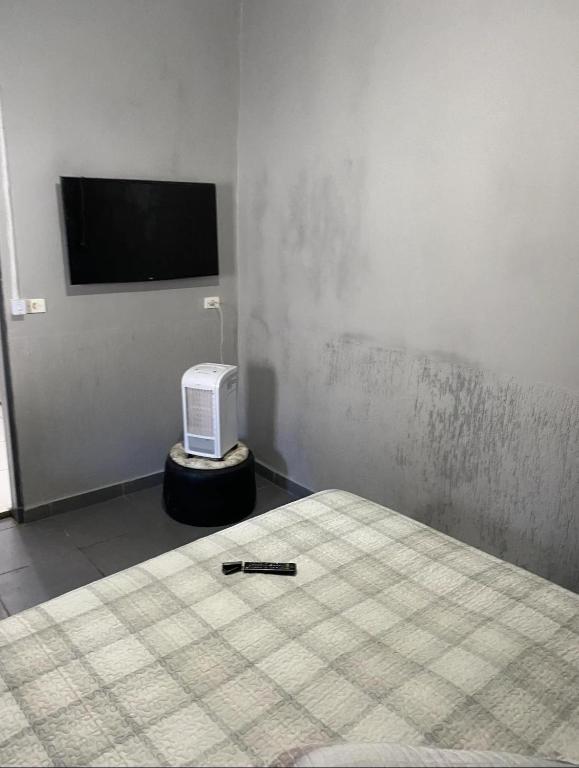 a bedroom with a bed with a bottle of booze next to a tv at Custo benefício Piri in Pirenópolis