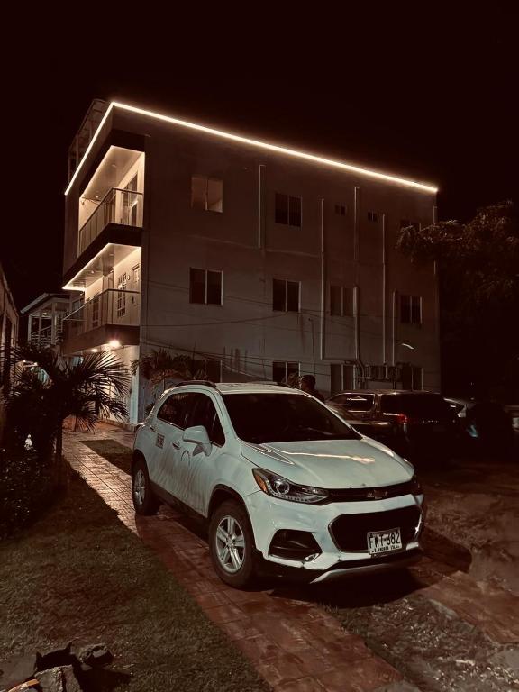 a white car parked in front of a building at night at APARTAMENTOS TURISTICOS ALTAMAR in San Andrés