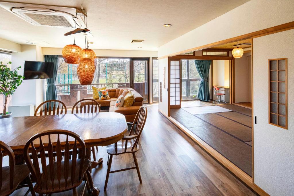 a dining room and living room with a table and chairs at Mitte Misono Apartments in Sapporo