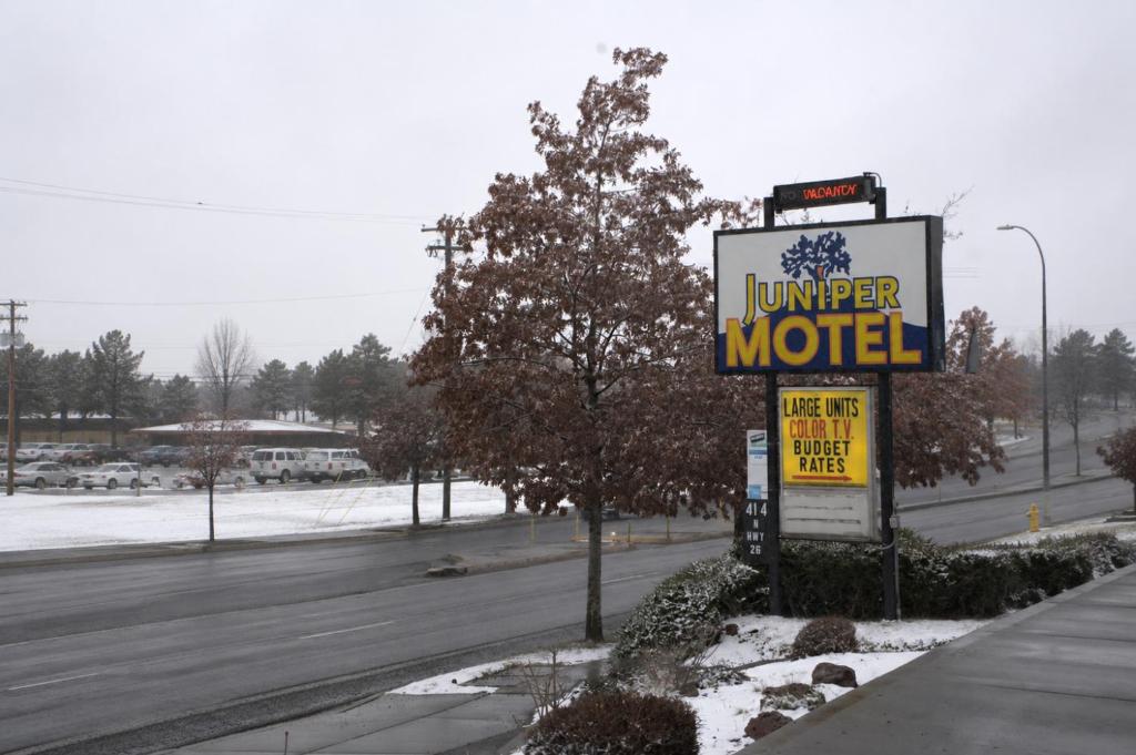 a sign for a motel on the side of a road at Juniper Motel Madras in Madras