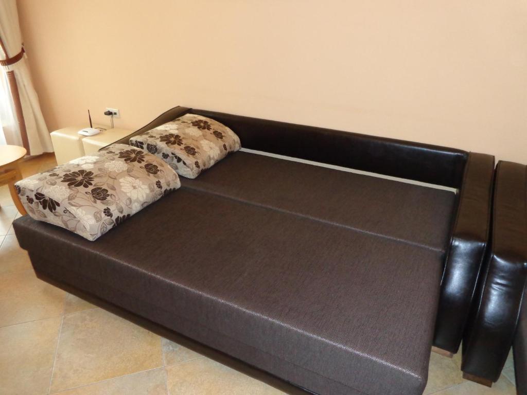 a black leather couch in a living room at Comfort Zamenhof in Varna City