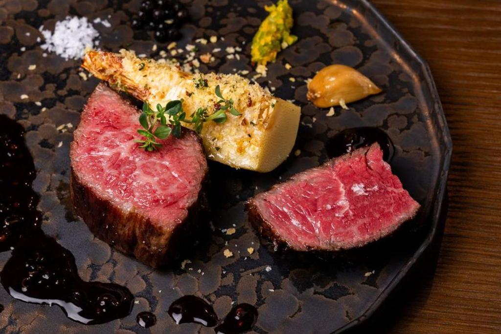 a plate of food with meat on a table at THE BLESS Awaji in Sumoto