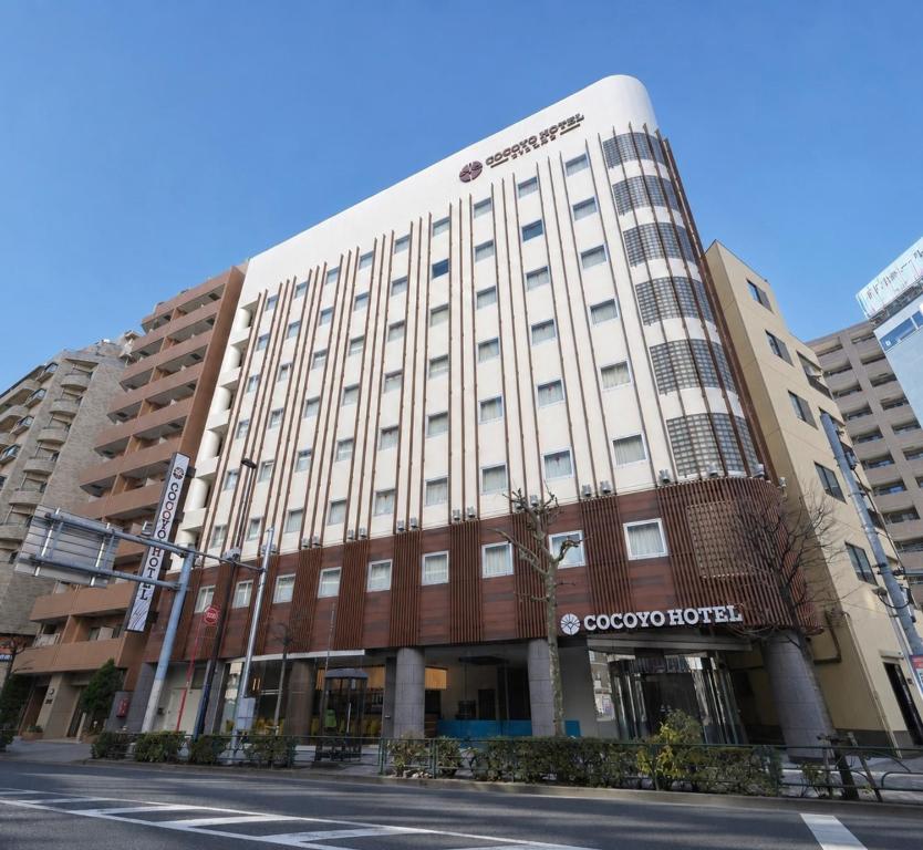 ein Gebäude an einer Straße neben einer Straße in der Unterkunft COCOYO Hotel Otsuka in Tokio