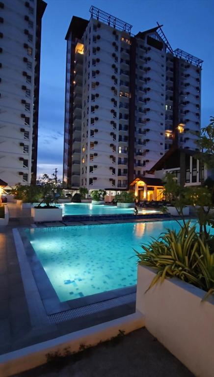 a swimming pool in front of some tall buildings at Kai's Luxe Balcony Suite at Royal Oceancrest Mactan in Mactan Island
