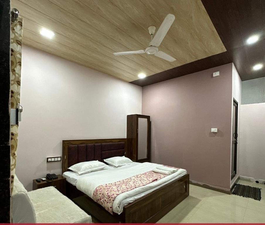 a bedroom with a bed and a ceiling fan at Hotel GMP in Hoshangābād