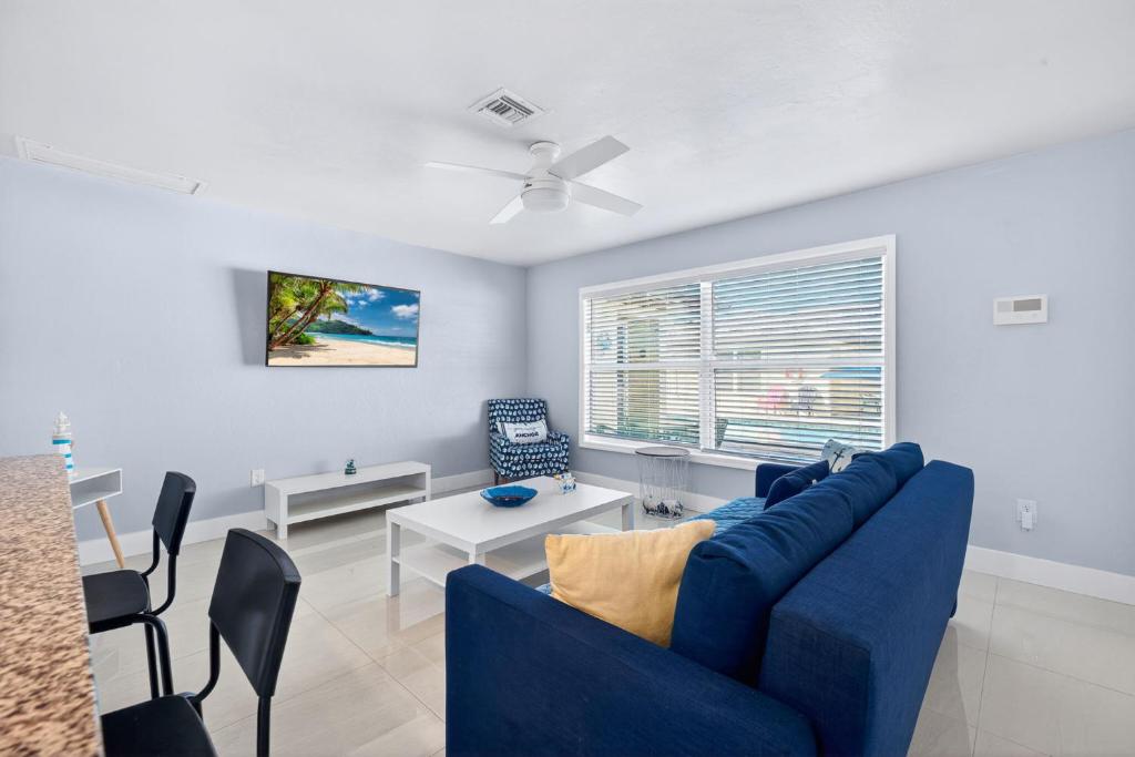 a living room with a blue couch and a table at Downtown Breeze in Cape Coral