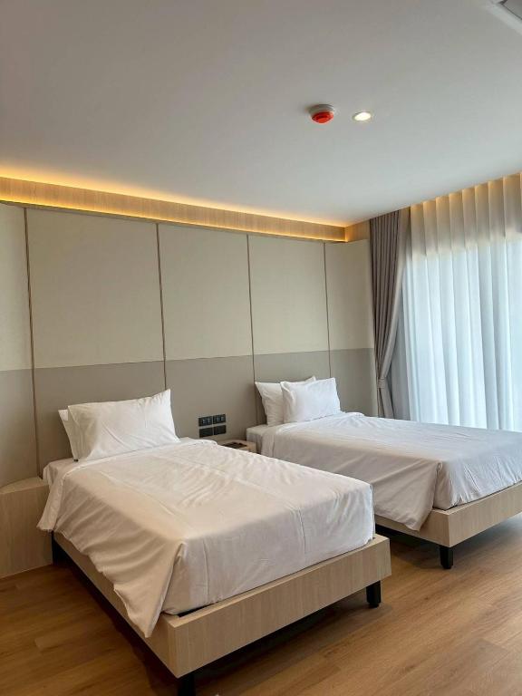 two beds sitting next to each other in a bedroom at Hermes Haven Hotel in Pattaya South