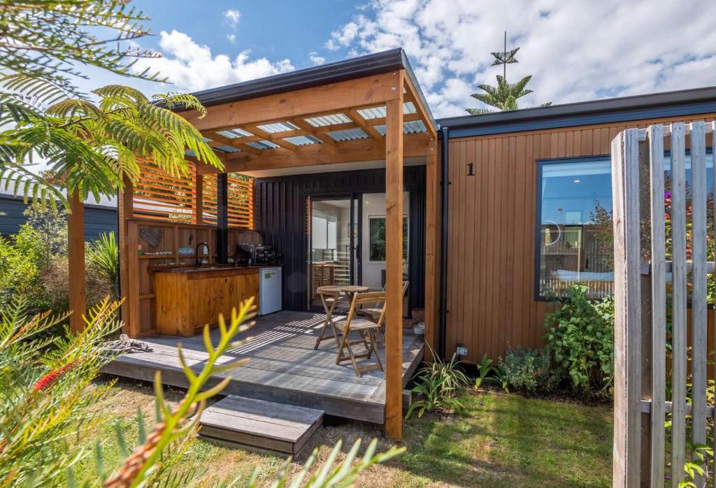 a house with a deck with a kitchen and a table at Studio at Pohara in Pohara