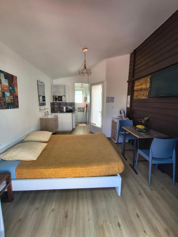 a bedroom with a bed and a table and a kitchen at Chez Frida in Entre-Deux