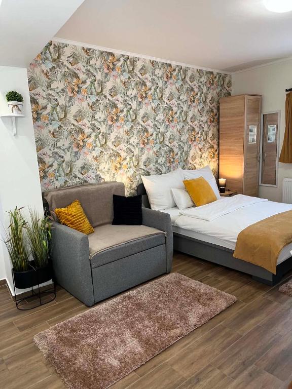 a bedroom with a bed and a couch and a wall at Várfal apartman I in Eger