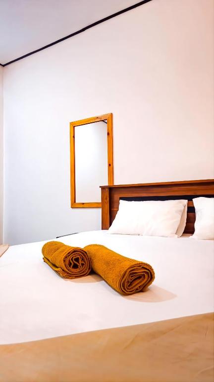 a blanket on a bed with a mirror at Surf and stay in Weligama