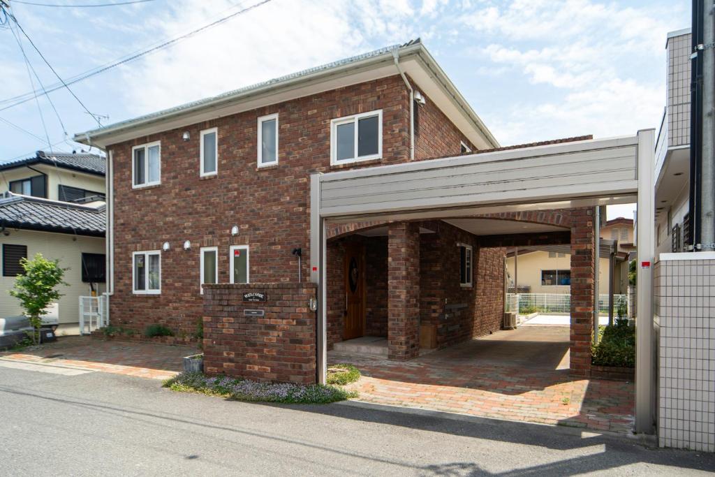 a brick house with an open garage at Nagano Villa 翠 in Nagano