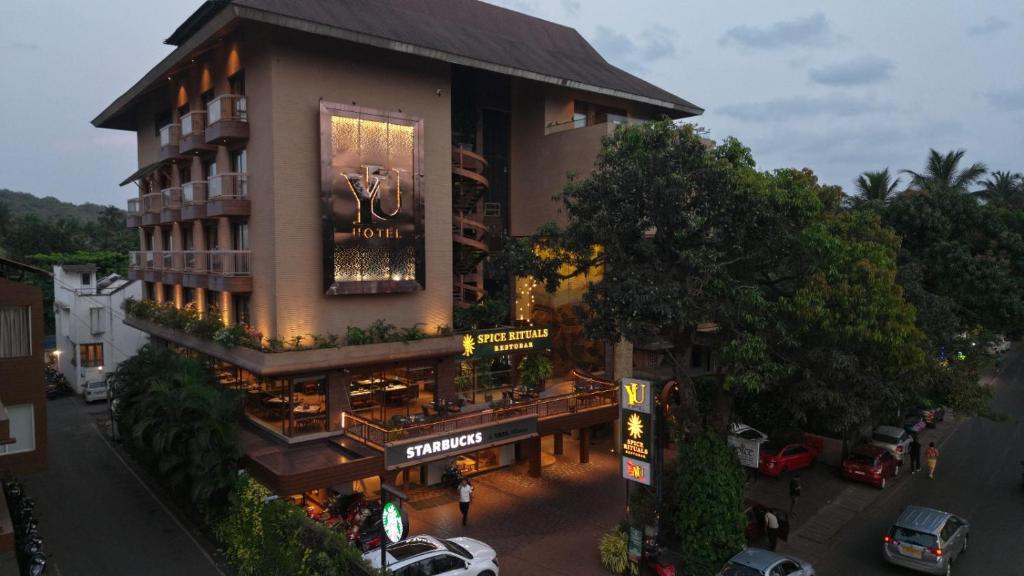 a building with a restaurant on the side of it at Yu Hotel, Candolim in Candolim