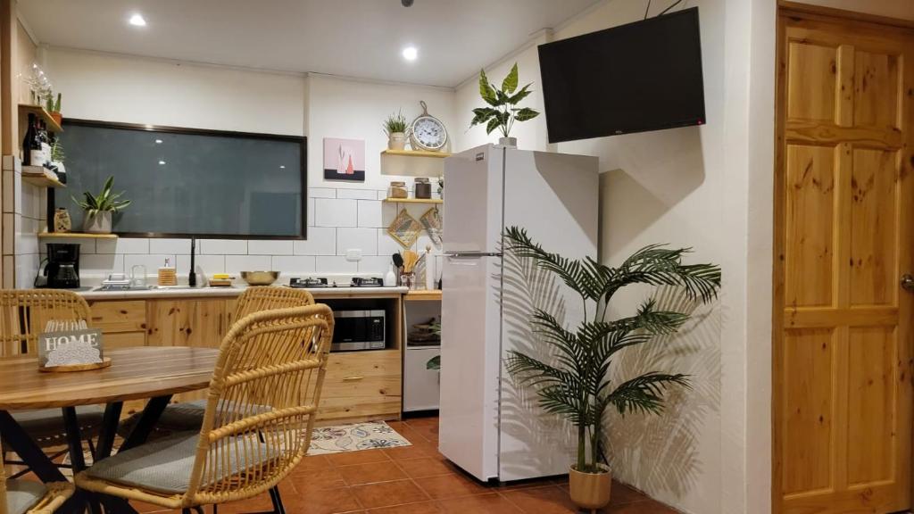a kitchen with a table and a white refrigerator at Home Chic in Quepos