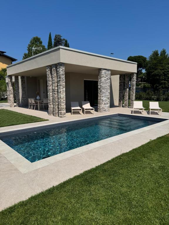 a swimming pool in front of a house at Villa Grace in Padenghe sul Garda