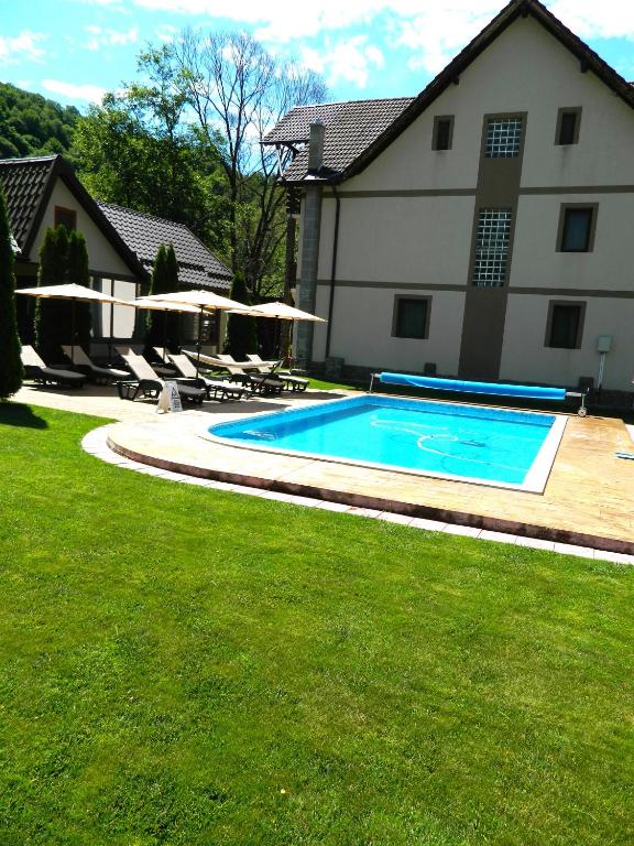 a swimming pool in a yard next to a house at Alpenhaus in Voineasa