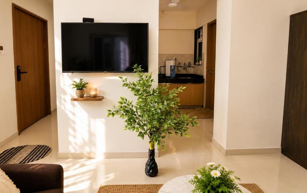 a living room with a vase with a plant in it at Hideout 2bhk Kharadi Near EON in Pune