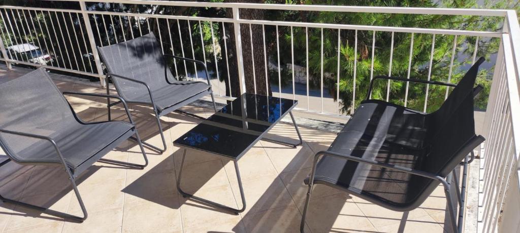 four chairs and a table on a balcony at Apartment Mila in Primošten