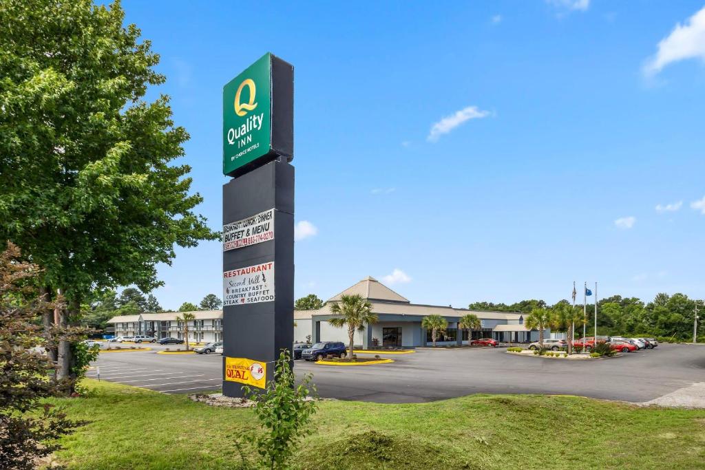 a sign for a gas station in a parking lot at Quality Inn Sumter near Shaw AFB in Sumter