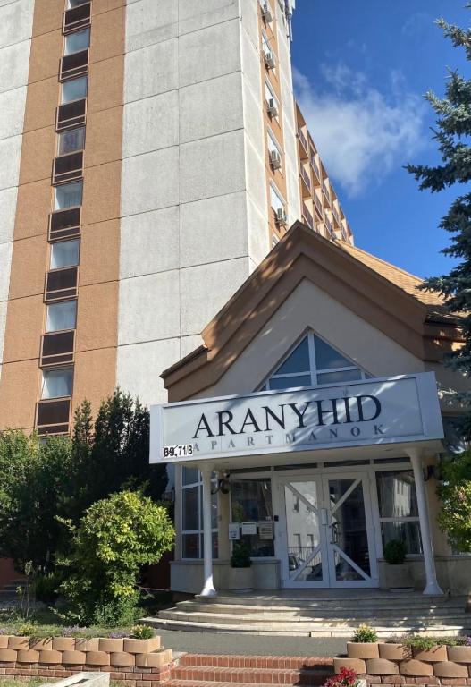 a building with a sign on the front of it at ARANYHÍD APARTMAN in Siófok
