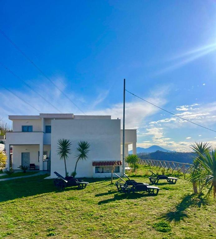 a white house with a yard with tables and chairs at Dodi's house in Pozzuoli