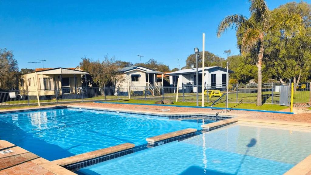 a large swimming pool in a yard with houses at The Beach Quarters in Broadwater