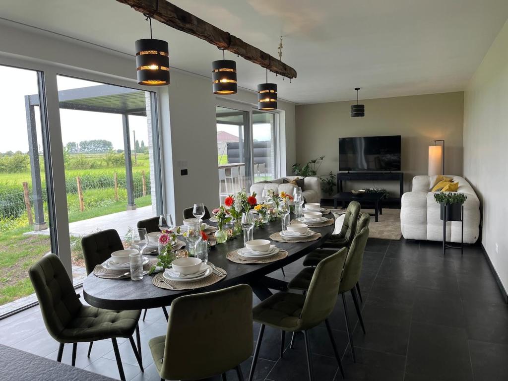 a dining room with a long table and chairs at Villa Houtave in Zuienkerke