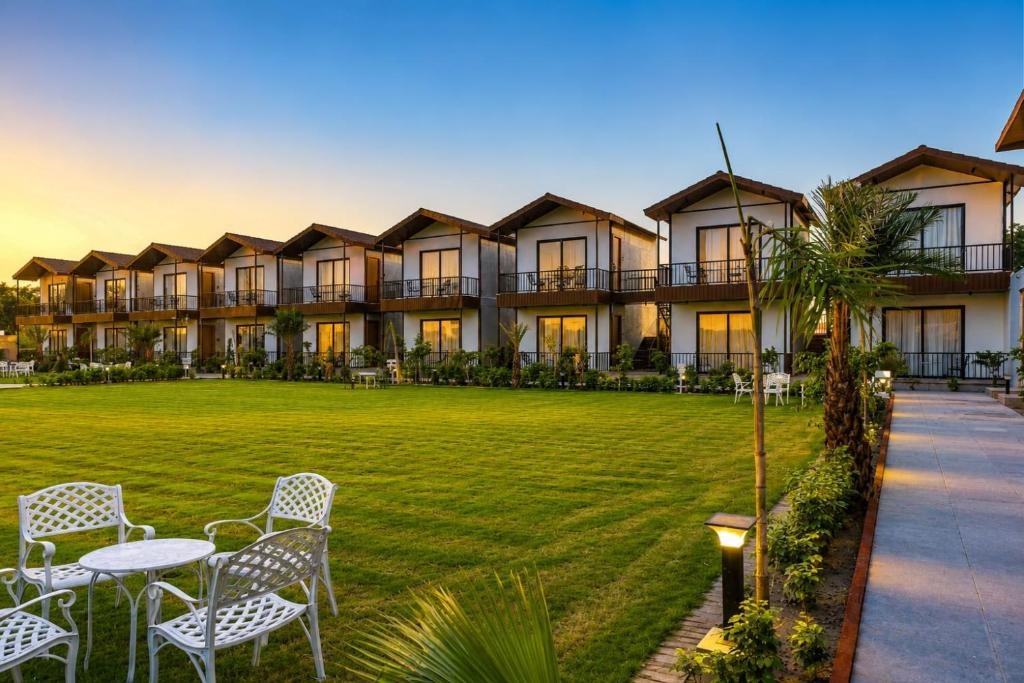 a resort with a lawn and tables and chairs at Aayovea Resort Ayodhya Near Ram Mandir & Saryu River in Ayodhya