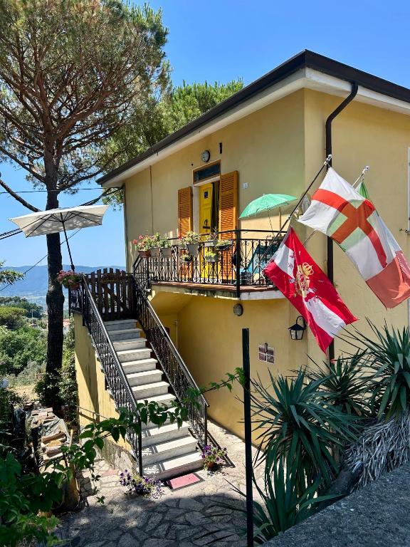 a house with a balcony with a flag on it at LA GINESTRA B&B in Fosdinovo