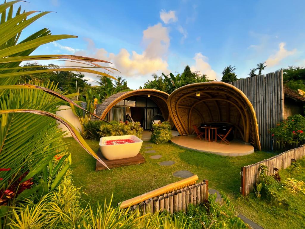 a garden with a yurt with a tub in the grass at Circle House Bamboo Sidemen in Silebeng