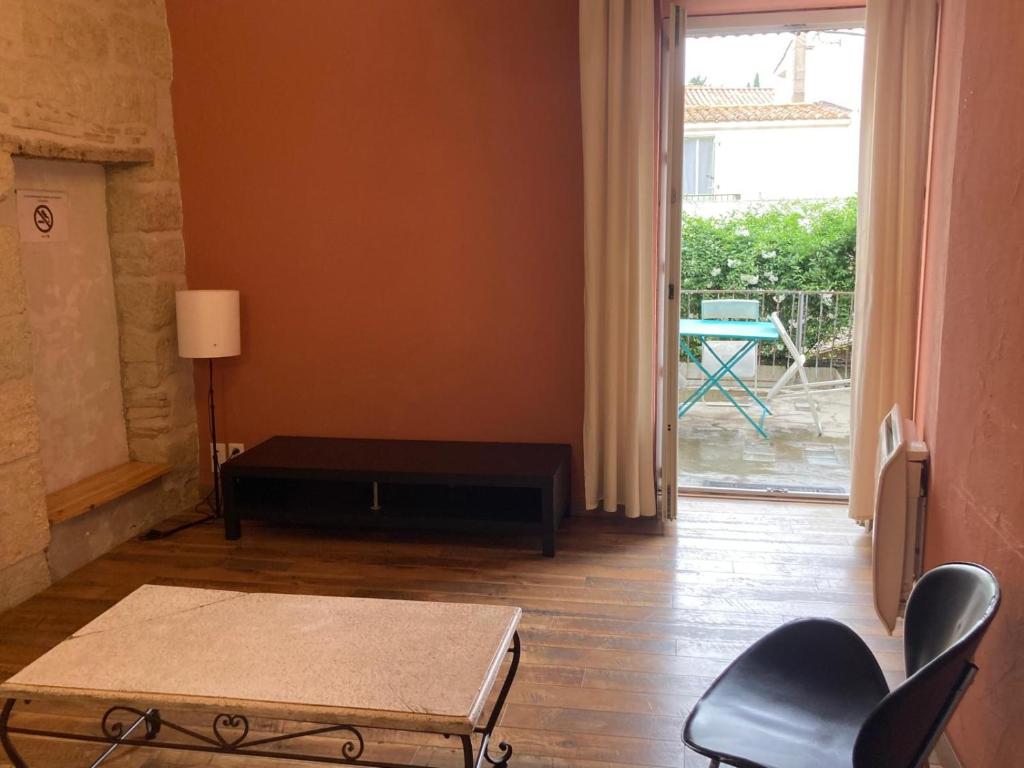 a living room with a table and chairs and a door at Charmant duplex 8 couchages 75 m2, terrasse 12 m2 dans village typique héraultais in Tourbes